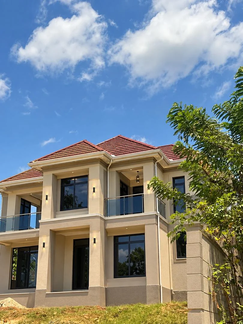 A residential building exterior with a tiled roof, columns and balcony details.